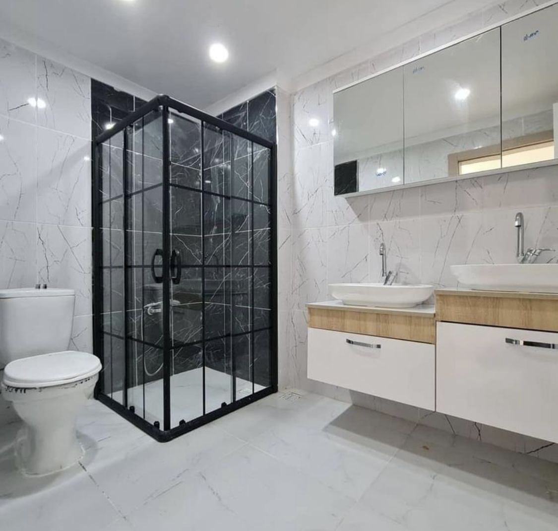 Siyah çerçeveli duşakabinli mermer desenli banyo