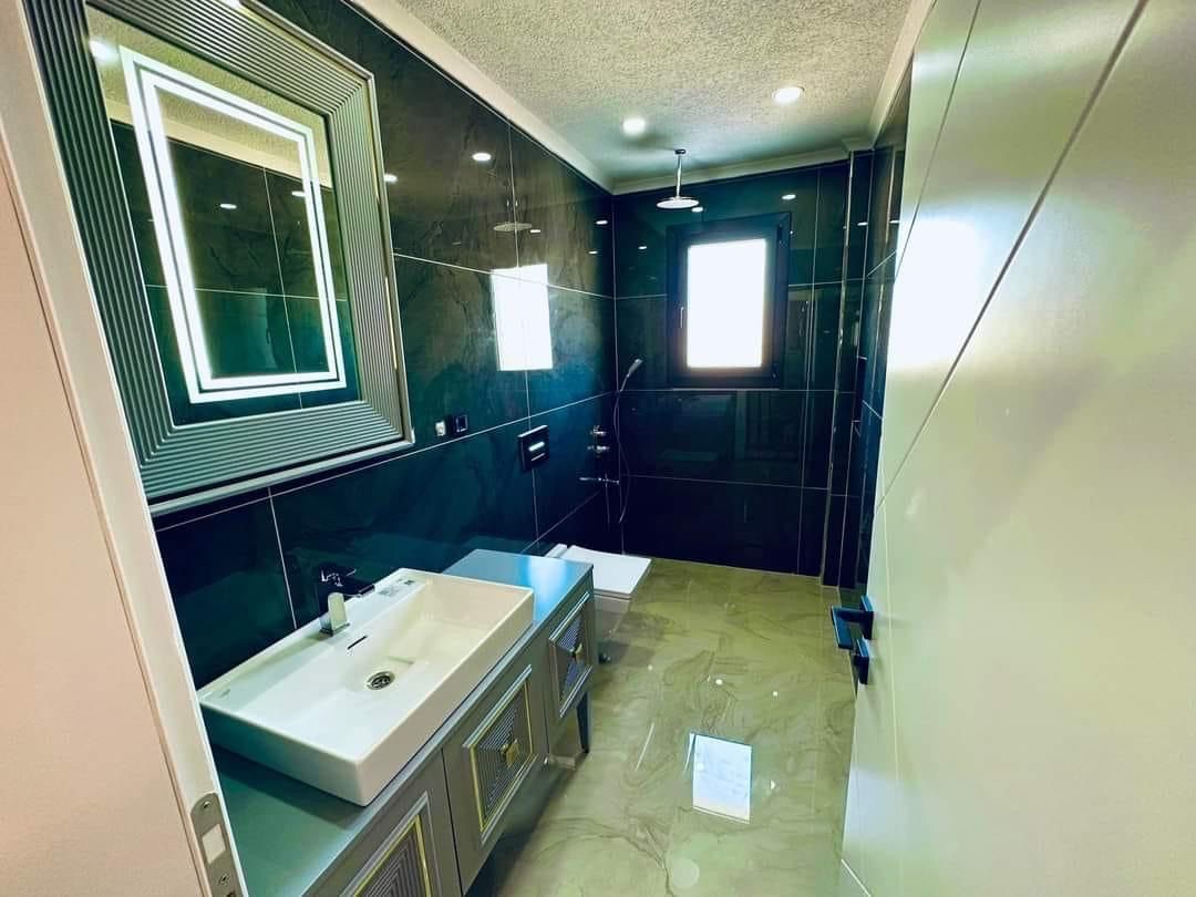 Koyu renkli, ışıklı aynalı banyo