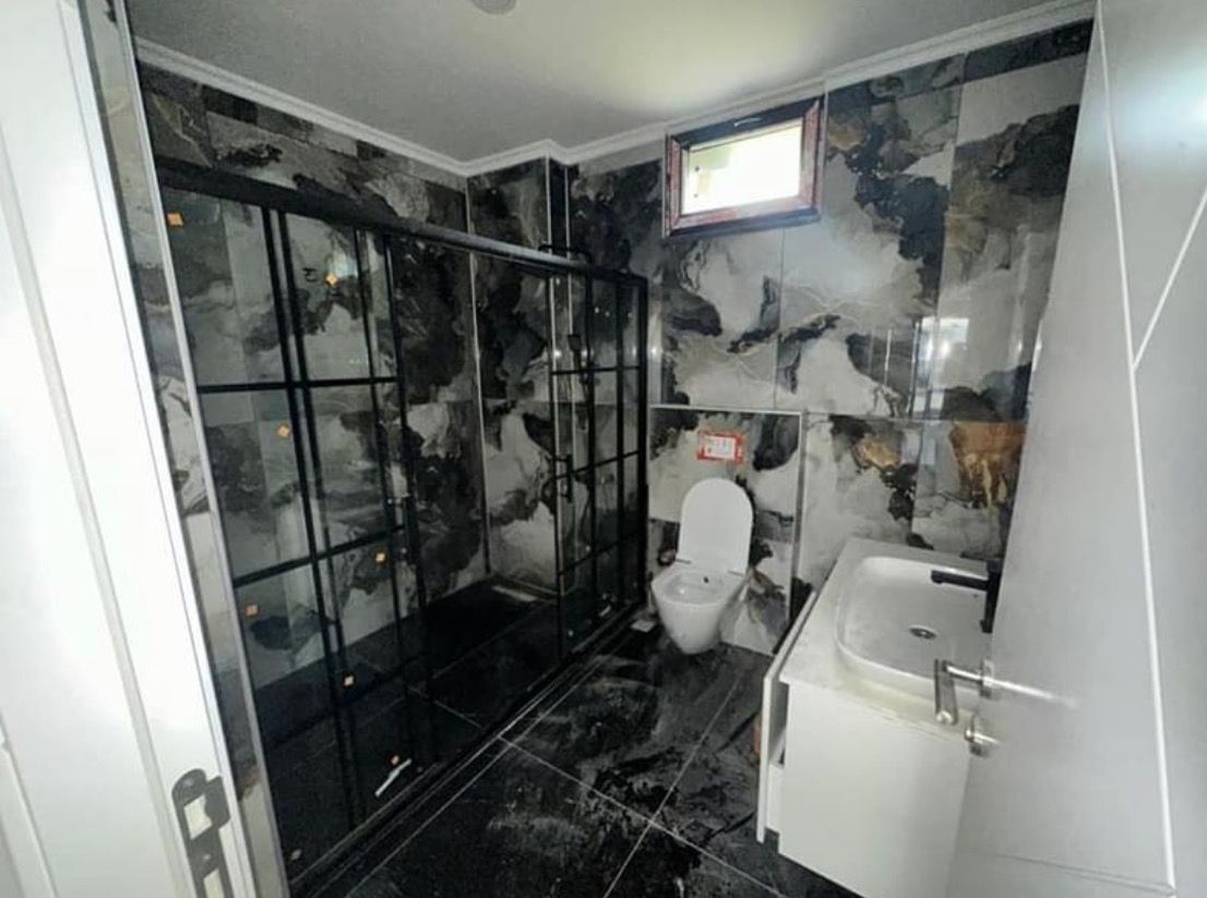 Siyah desenli duvar kaplamalı banyo