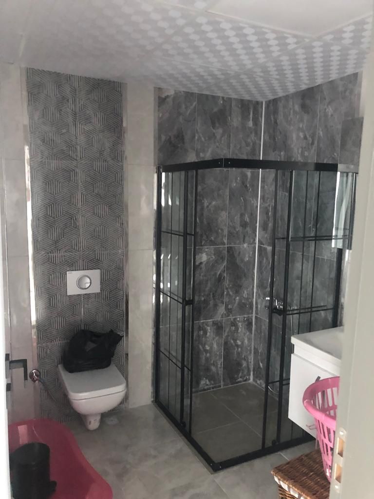Gri mermer kaplı duşakabinli banyo