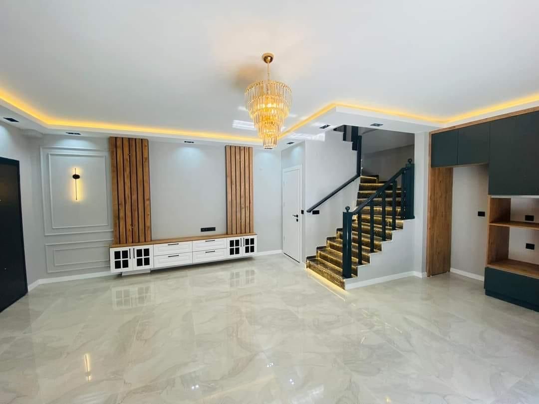 Gizli LED aydınlatmalı tavan, ahşap paneller ve merdivenli salon