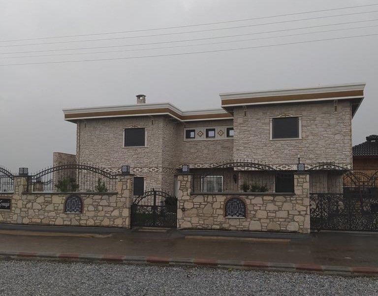 Taş cepheli, demir korkuluklu müstakil ev